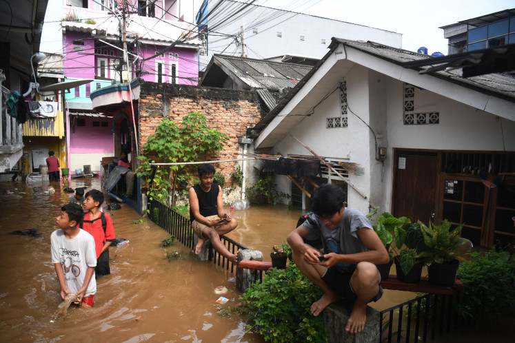 People wade through a flooded street on March 4, 2025, in Kebon Pala, Kampung Melayu, East Jakarta, where 59 neighborhood units (RT) and four roads were inundated by floodwaters reaching 30-300 centimeters when the Ciliwung River overflowed.
