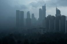 Clouds loom over buildings during rainfall in Jakarta on February 16, 2025.