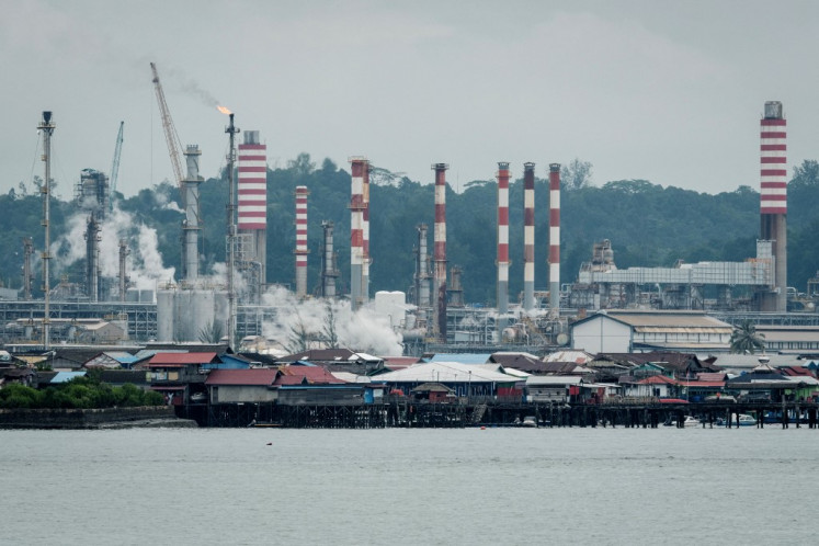 An oil refinery is seen from a ferry in Balikpapan, East Kalimantan, on July 9, 2024.