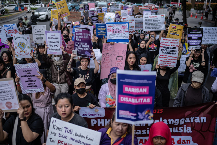 Participants march during a protest on March 8 organized by the Indonesian Women's Alliance (API) on the 50th International Women's Day demanding labor rights, gender equality and protections, in Jakarta.