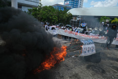 Civil service recruits burn tires during a demonstration in the front yard of the Southeast Sulawesi Legislative Council in Kendari on March 10, 2025, to protest the government’s decision to delay their inauguration.
