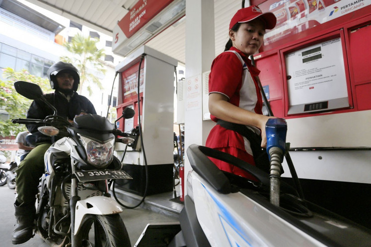 An attendant fills up a motorcycle with gasoline at a gas station owned by state-owned oil and gas company Pertamina in Jakarta. 
