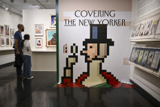 People look at The New Yorker cover art during the “Covering The New Yorker“ exhibition to commemorate the magazines 100th anniversary at L'Alliance New York Gallery in New York on March 6, 2025.