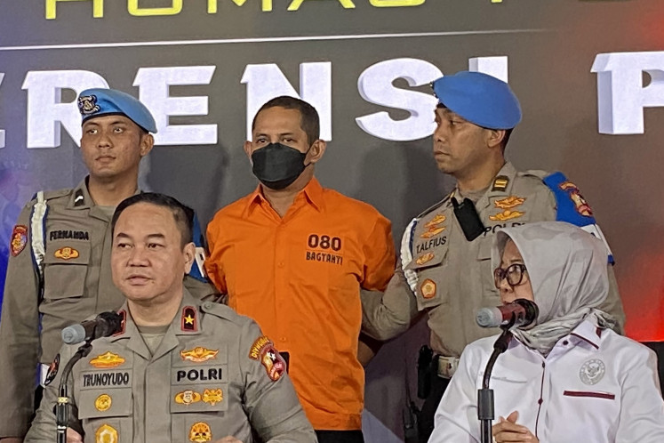 National Police spokesperson Brig. Gen. Trunoyudo Wisnu Andiko (front, left) and National Police Commission (Kompolnas) commissioner Ida Oetari Poernamasasi (front, right) talk to journalists during a press briefing at the National Police headquarters in Jakarta on March 13, 2025. The police have named Adj. Sr. Comr. Fajar Widyadharma Lukman (center) a suspect for allegedly committing sexual abuse against minors, as well as abusing narcotics.