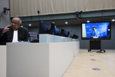 Lawyer Salvador Medialdea (left) sits in the courtroom during the first appearance via video link of his client former Philippine President Rodrigo Duterte (seen on a screen) before the International Criminal Court (ICC) on charge of crimes against humanity over his deadly crackdown on narcotics, in The Hague, the Netherlands, on March 14, 2025. The 79-year-old, the first ex-Asian head of state to face charges at the ICC, followed by videolink during a short hearing to inform him of the crimes he is alleged to have committed, as well as his rights as a defendant. Duterte stands accused of the crime against humanity of murder over his years-long campaign against drug users and dealers that rights groups said killed thousands.