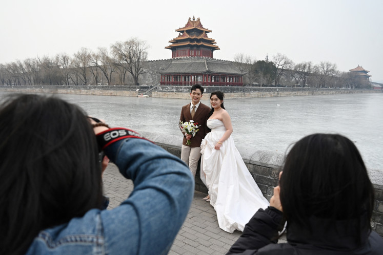A couple poses for wedding photos on Feb. 11, 2025, outside the Forbidden City in Beijing. China in 2024 saw a one-fifth decline in marriages, the latest sign of persistent demographic challenges as Beijing works to encourage births despite an uncertain economic outlook for young families.