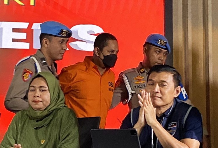 Former Ngada Police chief Adj. Sr. Comr. Fajar Widyadharma Lukman (center) is escorted out by National Police's Internal Affairs Division (Propam) officers during a press briefing at the National Police's headquarters in Jakarta on March 13, 2025. The police have named Fajar a suspect for allegedly sexually abusing minors and using narcotics.