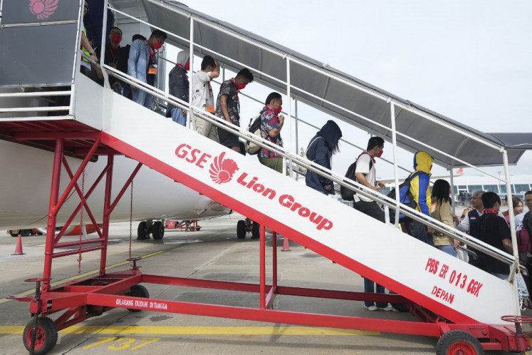 Indonesian nationals who had worked at scam centres in Myanmar disembark their aircraft upon arrival from Thailand, at the Soekarno-Hatta International Airport in Tangerang, Banten near Jakarta on March 18, 2025. 