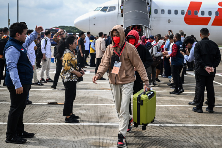 Indonesian nationals who had worked at scam centres in Myanmar are greeted by officials upon arrival from Thailand, at the Soekarno-Hatta International Airport in Tangerang, Banten near Jakarta on March 18, 2025. Indonesia on March 18 began repatriating more than 500 of its nationals freed from online scam centres in Myanmar, officials said, bringing them home from grim holding camps in Thailand where many have languished for weeks.