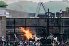 Protesters burn tires during a protest against a revision to the Indonesian Military (TNI) Law in front of the Senayan legislative complex in Jakarta on March 20, 2025. The House of Representatives passed the TNI Law revision at a plenary session on March 20 despite opposition and concerns from the public that the new law would expand the military's role in the country's civilian affairs.
