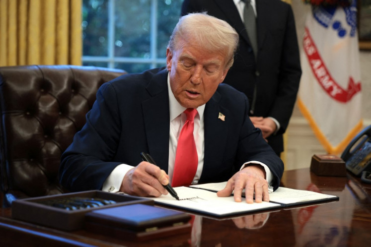 United States President Donald Trump signs an executive order on Feb. 25, 2025, in the Oval Office at the White House in Washington, DC.