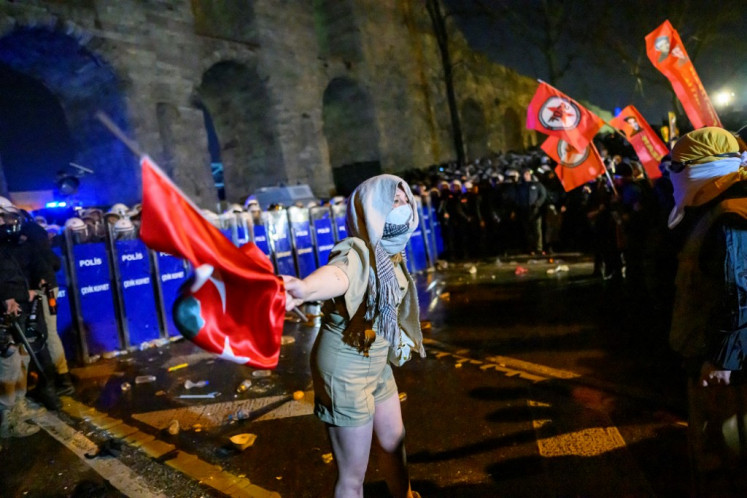 A protester gestures during clashes with riot police at a demonstration following the arrest of Istanbul's mayor near the city hall of Istanbul, Turkey on March 21, 2025. Thousands have rallied in Istanbul for a third night of demonstrations in support of its arrested mayor Ekrem Imamoglu, the Incumbent President Recep Tayyip Erdogan's chief political rival, who was detained just days before he is expected to be formally named as a candidate in the country's 2028 presidential election. The arrest, over two investigations into graft and “supporting terror“, is described by Imamoglu's opposition party CHP as a politically-motivated “coup“.
