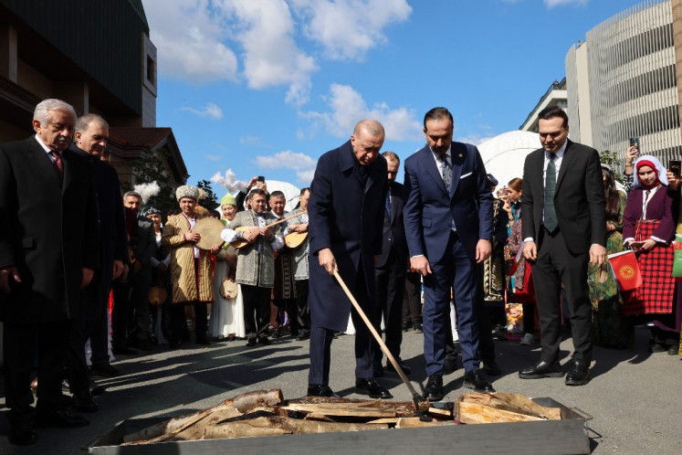 This handout photograph taken and released by Turkish Presidency Press Office on March 21, 2025, shows Turkish President Recep Tayyip Erdogan (left) lighting the bonfire during Nowruz event marking the New Year of the Persian calendar and the first day of spring in Istanbul.