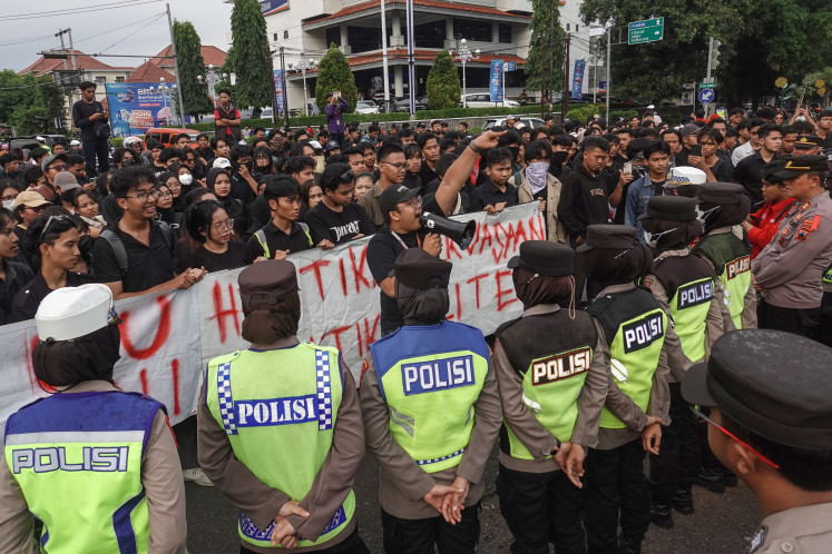 Police are on guard in front of protesters who reject the newly passed amendment of the Indonesian Military (TNI) law in Banyumas, Central Java, on March 21, 2025. 