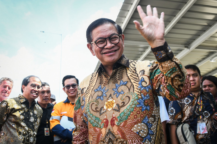 Jakarta Governor Pramono Anung waves to journalists during an inspection of a refuse-derived fuel (RDF) plant in Rorotan, North Jakarta, on March 20, 2025, following complaints of thick and smelly smoke from the newly built waste-to-energy plant.