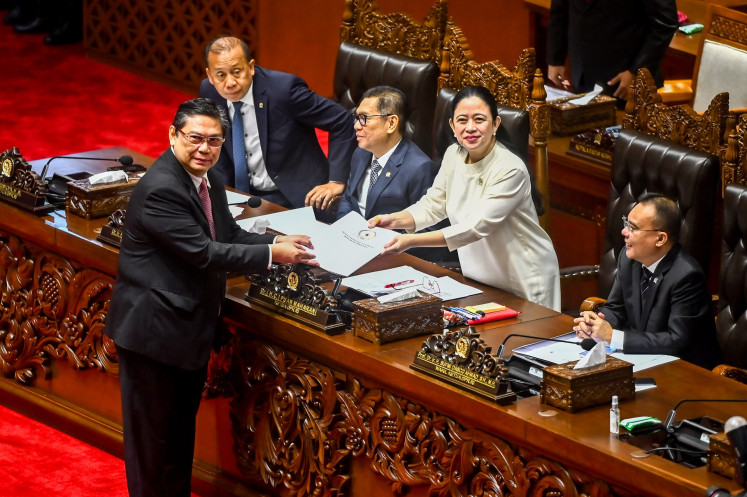 House of Representatives Commission I chair Utut Adianto (left) of the Indonesian Democratic Party of Struggle (PDI-P) hands over the report on the deliberations for the Indonesian Military (TNI) Law revision to Speaker and fellow PDI-P politician Puan Maharani (second right) during a plenary session at the Senayan legislative complex in Jakarta on March 20, 2025, with Deputy Speakers Sufmi Dasco Ahmad (right) of the Gerindra Party, Adies Kadir (third right) of the Golkar Party and Saan Mustopa (second left) of the NasDem Party observing.