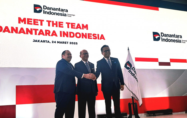 Danantara's chief investment officer Pandu Sjahrir (left), CEO Rosan Roeslani (middle), chief operating officer Dony Oskaria (right) join hands for a photo at the management team announcement in Jakarta on Mar. 24, 2025.