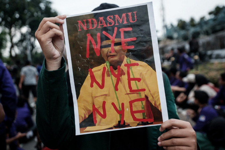 A university student holds a poster saying “Ndasmu“, a highly derogatory Javanese word which translates into “your head“, on Feb. 20, 2025, during an Indonesia Gelap (Dark Indonesia) protest against President Prabowo Subianto's administration calling for various demands, including reviews of government budget cuts and the free nutritious meal program, in Jakarta.