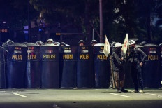 Police officers disperse protesters during a protest against the revision of the Indonesian Military (TNI) Law in Jakarta on March 20, 2025.