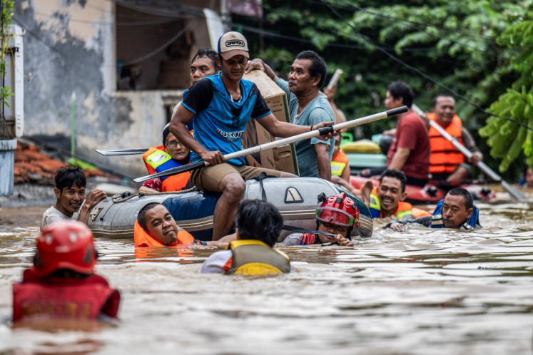 Officers and volunteers evacuate residents affected by flooding in Rawajati village, Pancoran, South Jakarta, on March 4, 2025.