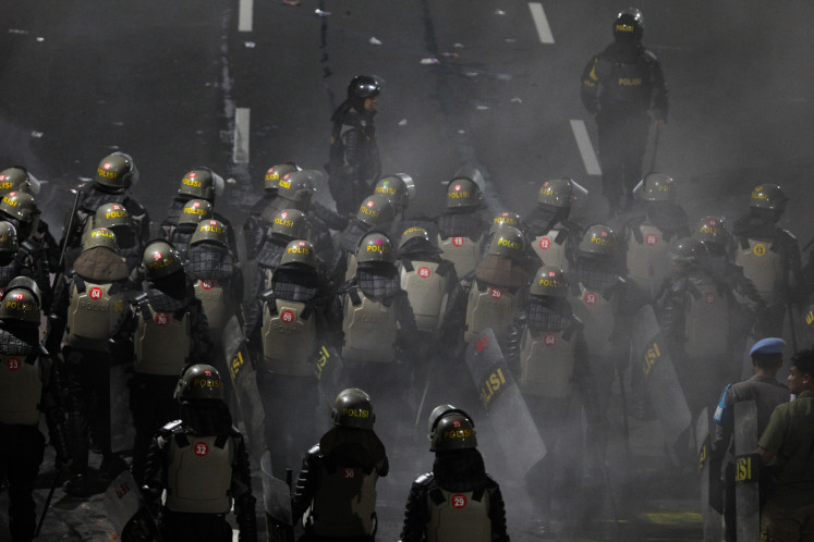 Police officers disperse demonstrators protesting the controversial revision of the Indonesian Military (TNI) Law in Surabaya, East Java, on March 24.