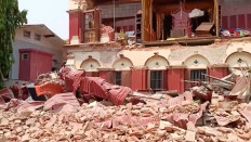 People stand near a collapsed temple following an earthquake in Mandalay, Myanmar, March 28, 2025, in this screengrab taken from social media video.