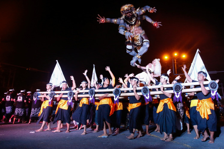 Balinese men carry an Ogoh-ogoh, an evil effigy, during a parade ahead of the holy day of Nyepi, which is a day of silence for self-reflection to celebrate the Balinese Hindu new year in Denpasar, Bali on March 28, 2025.