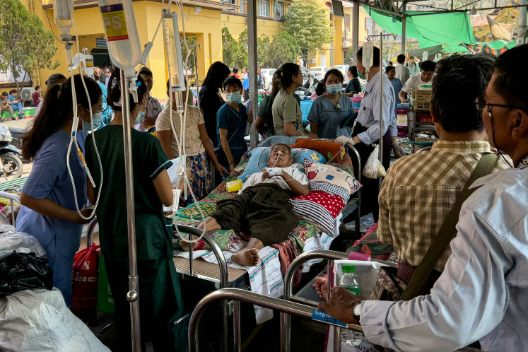 A patient lies on a bed surrounded by medical workers in the compound of Mandalay General Hospital in Mandalay on March 31, 2025, three days after the deadly Myanmar earthquake. Hopes were fading of finding more survivors in the rubble of Mandalay, where some residents spent a third night sleeping in the open after a massive earthquake killed at least 1,700 people in Myanmar and neighbouring Thailand. 