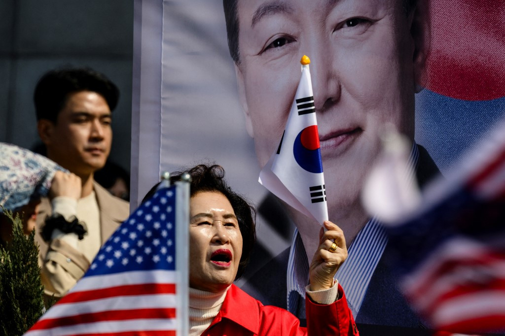 Supporters of South Korea president Yoon Suk Yeol (pictured on banner) react prior to the announcement of the Constitutional Court's verdict on Yoon's impeachment outside the presidential residence in Seoul on April 4, 2025. South Korea's Constitutional Court unanimously upheld president Yoon Suk Yeol's impeachment over his disastrous martial law declaration, stripping him of office and triggering fresh elections after months of political turmoil.