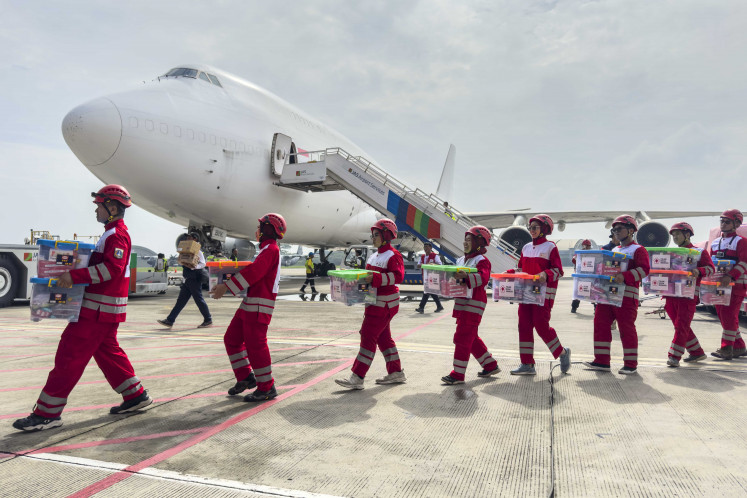 Indonesian Red Cross (PMI) personnel carry packages of humanitarian aid during the departure ceremony for Indonesia's humanitarian aid mission following the 7.7-magnitude earthquake rocking Myanmar at the Halim Perdanakusuma Air Force Base in Jakarta on April 3, 2025. The US$1.3 million-worth of aid consists of food, medicine, medical equipment and other equipment needed to evacuate people affected by the disaster.