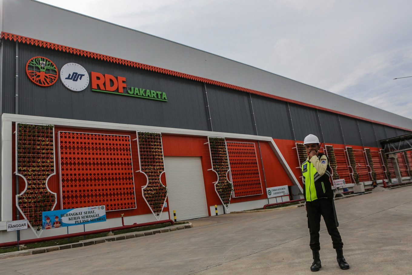 A security guard stands guard in front of the refuse-derived fuel (RDF) plant in Rorotan, North Jakarta, on March 25. The Jakarta Environmental Agency suspended the plant's operations to allow for the installation of more facilities, such as deodorizers and air quality monitoring stations, to prevent the site from emitting thick and pungent smoke in the future.