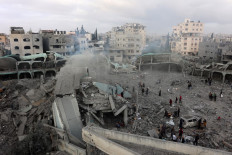 In this aerial view, Palestinians check the devastation in the yard of a destroyed school, a day after it was hit by an Israeli strike, in the al-Tuffah neighbourhood of Gaza City on April 4, 2025. Gaza's civil defence agency said on April 3 that at least 31 people, including children, were killed in the Israeli strike on the school serving as a shelter for Palestinians displaced by the war.