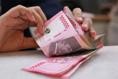 A clerk counts rupiah banknotes on May 2, 2024, at a money changer in Jakarta.