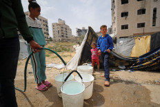 Palestinians fill up buckets with water in Gaza City on April 6, 2025.