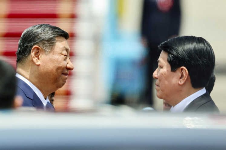 Chinese President Xi Jinping (left) speaks with Vietnam's President Luong Cuong (right) as he arrives for a two-day state visit at Hanoi's Noi Bai International Airport on April 14, 2025. His tour of Southeast Asia will also see him visit Malaysia and Cambodia as Beijing seeks to strengthen regional trade ties and offset the impact of huge tariffs unleashed by his US counterpart.
