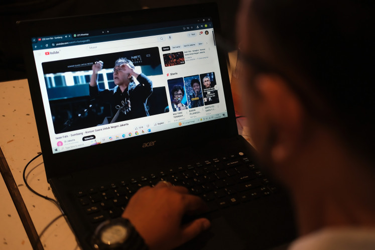 A coffee shop visitor watches a video on YouTube on his computer in Pontianak, West Kalimantan, on April 12, 2025.