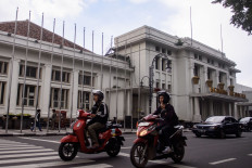 On the move: Motorists ride in front of the Merdeka Building on April 16 in Bandung, West Java.