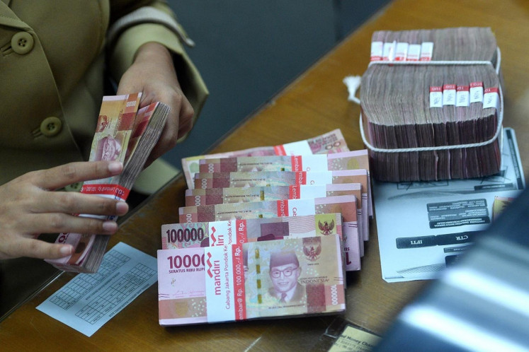 Red brick: An employee counts rupiah bills at a money changer on March 14 in Jakarta. 

