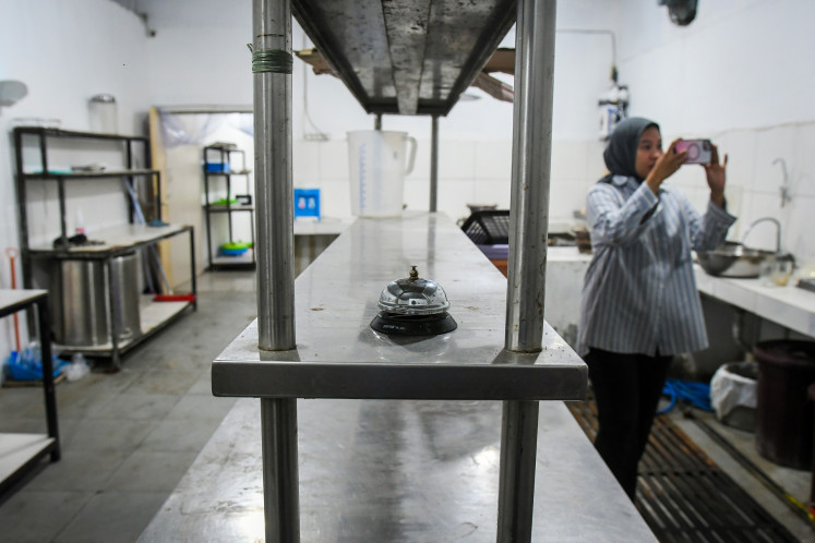 A journalist takes a photo of a kitchen supplying the free nutritious meal program, officially called nutrition fulfillment service units (SPPG), in Kalibata, South Jakarta, on April 16, 2025. The kitchen will resume operation after previously stopping due to limited funding.