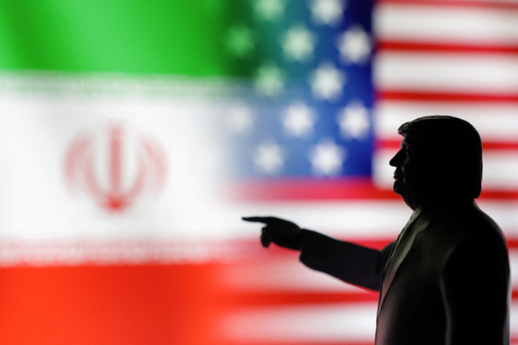 A 3D-printed miniature model depicting United States President Donald Trump, with Iranian and US flags on the background in this illustration taken on April 17, 2025.
