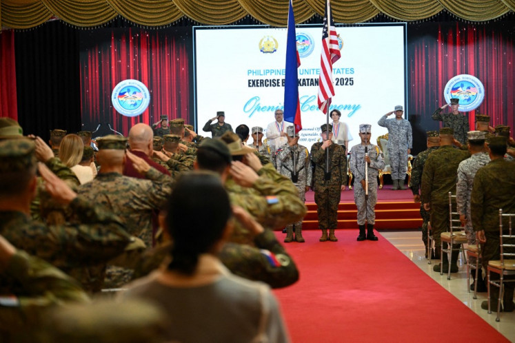 US and Philippine soldiers carry their national flags during the opening ceremony of the annual US-Philippines Balikatan joint military exercise at camp Aguinaldo in Manila on April 21, 2025. 