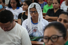 A Catholic faithful wears a T-shirt with a portrait of Pope Francis, as Catholics gather to attend a special Mass following news of his death, at Balide Church in Dili, East Timor, on April 21, 2025. 