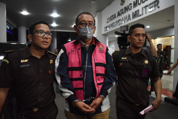 JakTV editor in chief Tian Bahtiar (center) is escorted by security officers to a prisoner transport vehicle on April 22, 2025, following his questioning at the Attorney General’s Office in Kebayoran Baru, South Jakarta. Antara/Indrianto Eko Suwarso/foc
