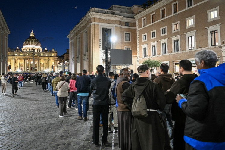 People queue to pay their respects to late Pope Francis as his body lies in state, with St Peter's Basilica viewed in the background on Via della Conciliazione near the Vatican in Rome, on April 23, 2025. Tens of thousands of mourners began saying their last goodbyes to Pope Francis at St Peter's Basilica Wednesday, as the body of the late Argentine pontiff began three days of lying in state. 