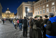People queue to pay their respects to late Pope Francis as his body lies in state, with St Peter's Basilica viewed in the background on Via della Conciliazione near the Vatican in Rome, on April 23, 2025. Tens of thousands of mourners began saying their last goodbyes to Pope Francis at St Peter's Basilica Wednesday, as the body of the late Argentine pontiff began three days of lying in state. 