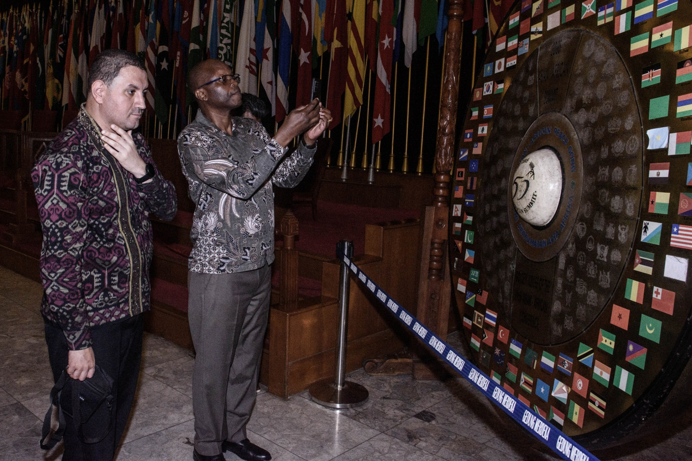Two diplomatic delegates inspect the gong that was used to officiate the 50th anniversary of the 1955 Asia-Africa Conference,on April 23 at the Merdeka Building in Bandung, West Java. More than a dozen foreign dignitaries visited the Asia-Africa Museum as part of an event to commemorate the 70th anniversary of the conference in 2025.