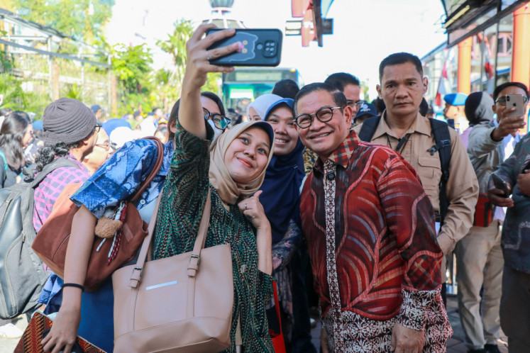 Jakarta Governor Pramono Anung (right) poses with a number of commuters at Blok M bus terminal in South Jakarta on April 24, 2025, on the sidelines of the launching of new Transjabodetabek bus route connecting Blok M and Tangerang's Alam Sutera.