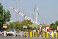 Pakistanis walk near the Pakistan-India Wagah border post on the outskirts of Lahore on April 24, 2025. 
