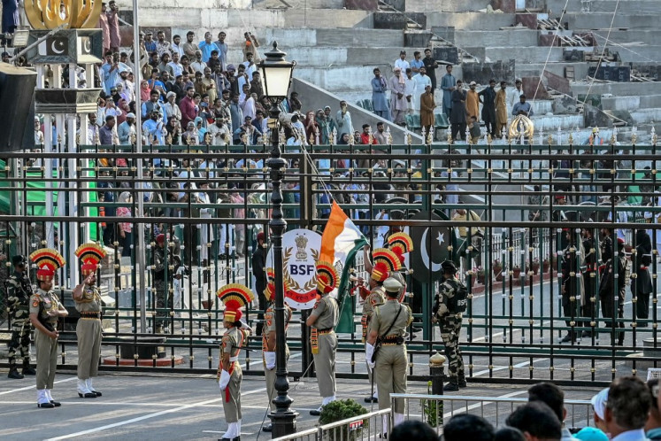 Indian Border Security Force personnel (brown) and Pakistani Rangers (black) take part in the beating retreat ceremony at the border gates of India and Pakistan at the Wagah border post, about 35 kilometers from Amritsar on April 25, 2025.