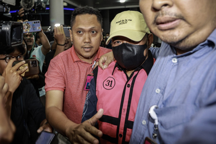 Attorney General's Office (AGO) investigators escort former Central Jakarta District Court judge Djuyamto (center) after an interrogation session at the AGO's headquarters in Jakarta on April 14, 2025. The AGO named four judges suspects in a bribery case pertaining to the acquittal of three palm oil companies in another corruption case relating to crude palm oil exports. (Antara/Dhemas Reviyanto)